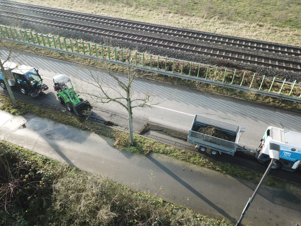 Reinigungskolonne - an der Spitze die Kehrsaugmaschine mit Wildkrautbürste und Anhänger